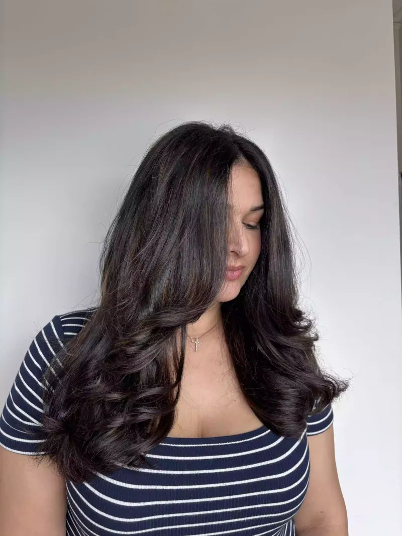 Long dark brunette hair styled in soft, glossy curls